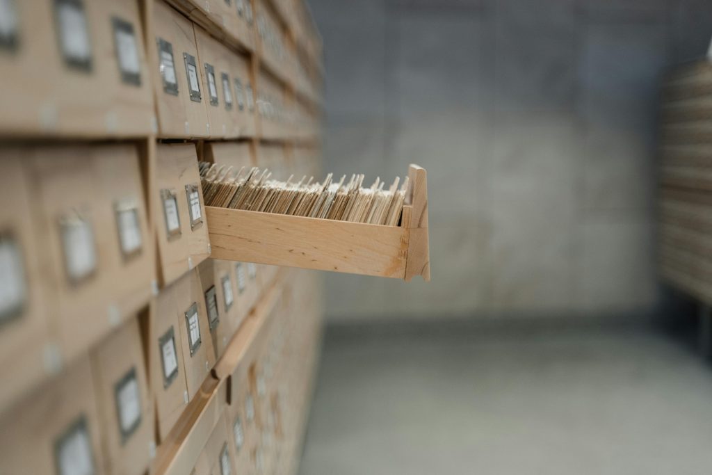 A vintage card catalog drawer in an archive library setting, highlighting organization and history.